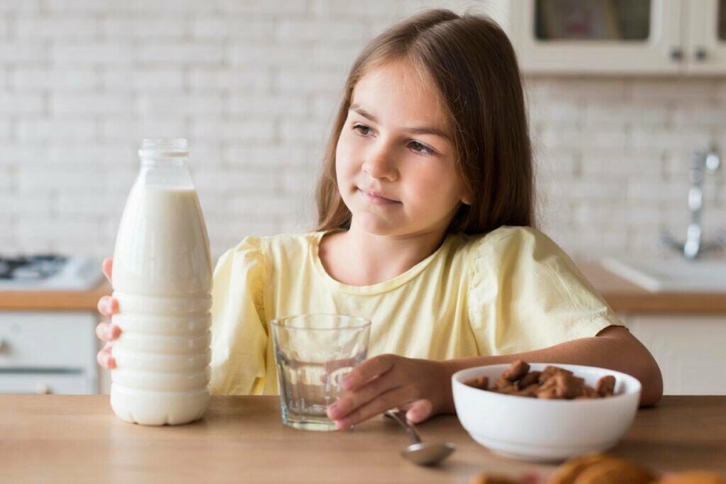 medium shot girl holding milk bottle 1