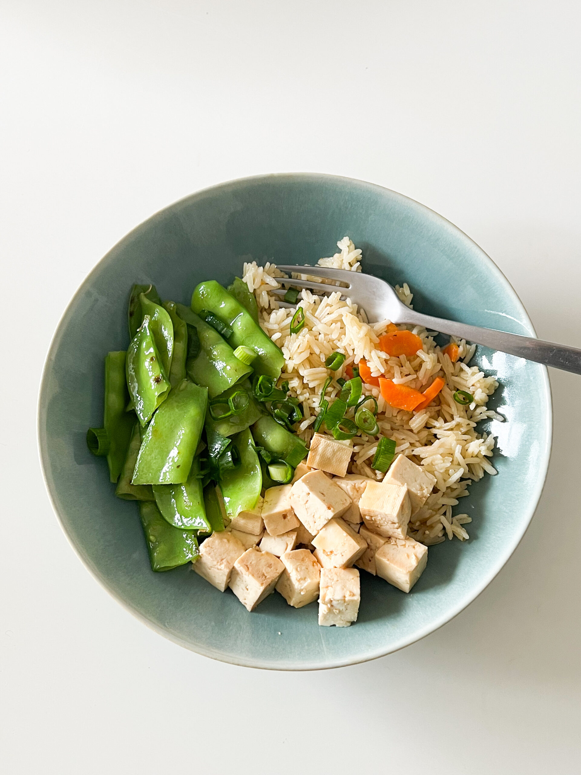 Bowl com arroz de cenoura, tofu marinado e legumes salteados